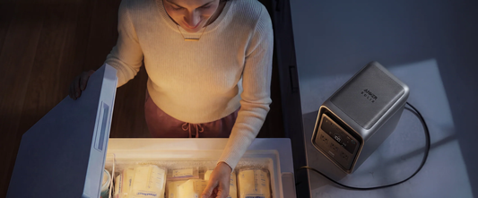 Person checking refrigerator food supply with Anker SOLIX S2000 backup power station running nearby